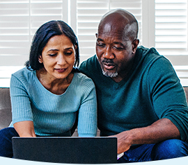 Happy couple looking into CareFirst plan on their laptop