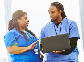 Medical professionals wearing scrubs consulting with one another
