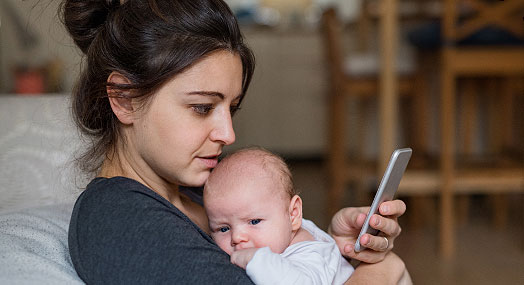 Mother on her phone holding a baby