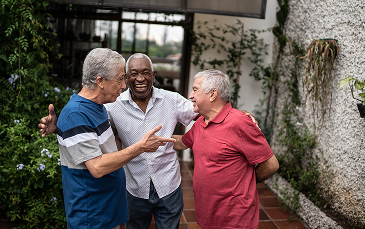 Neighbors gather outdoors, smiling and enjoying a friendly conversation in a welcoming community setting