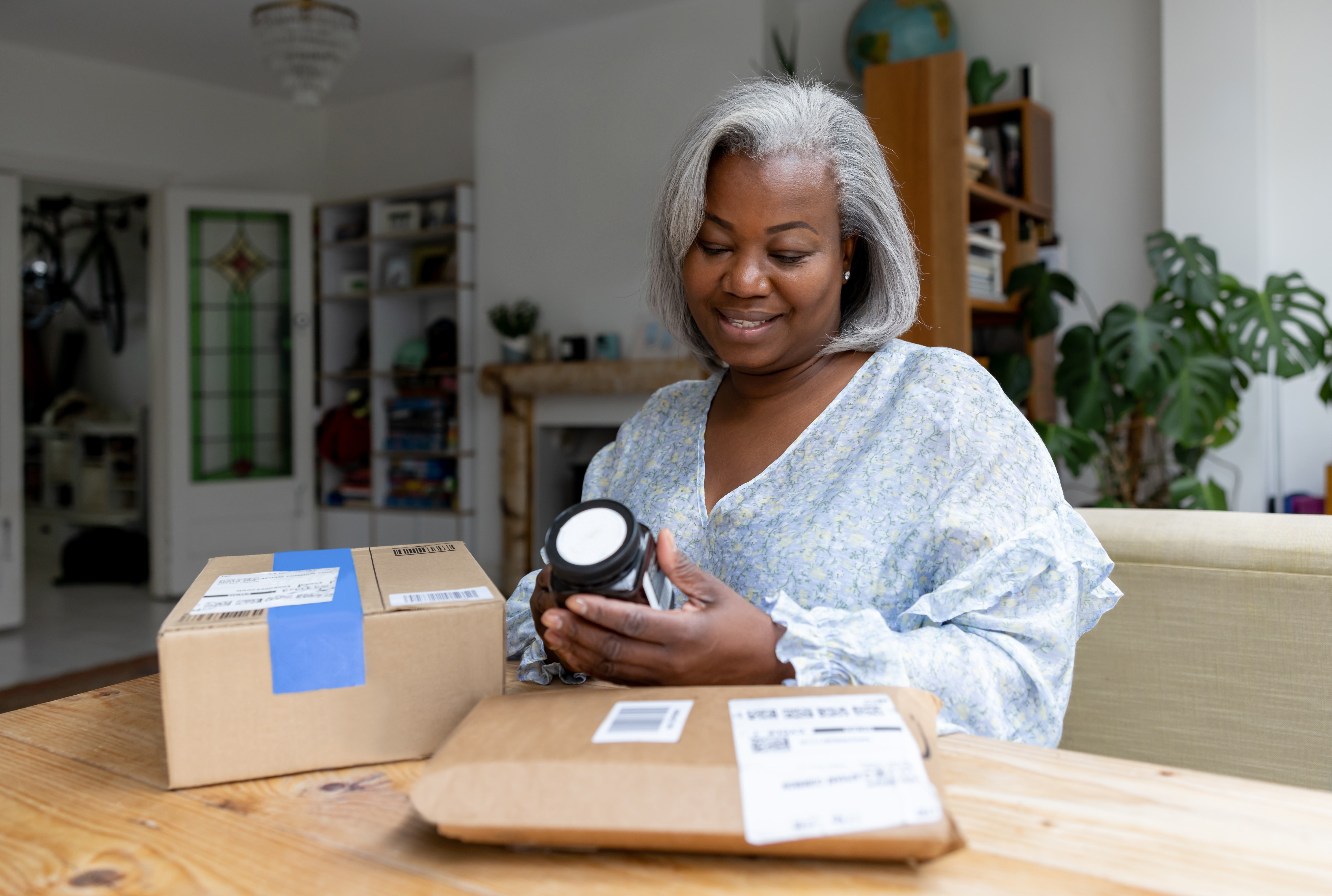 Woman opening a prescription delivery package at home