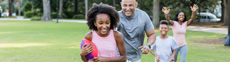 Family of four playing touch football